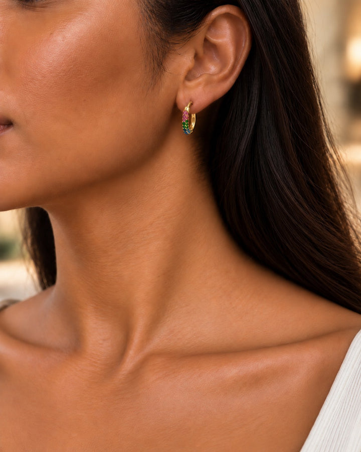 Elli Jewellery gold plated hoop earrings with multicoloured crystals worn by a model