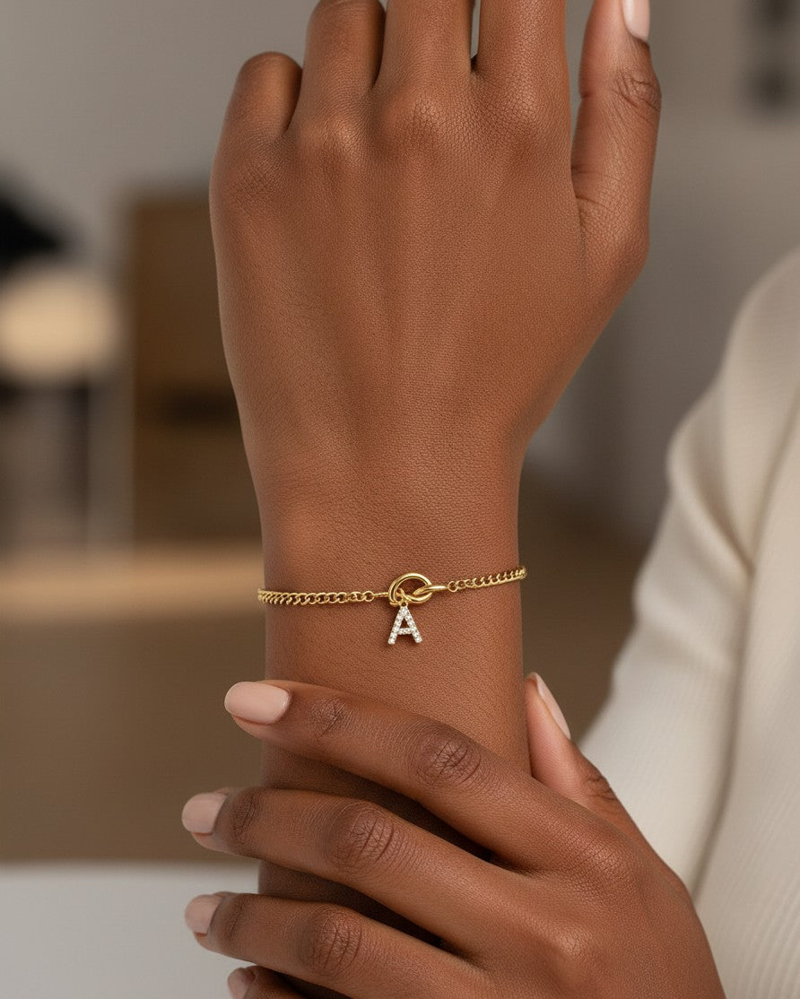 Elli Jewellery gold-plated chain bracelet featuring a sparkling crystal letter A charm worn on a woman's wrist