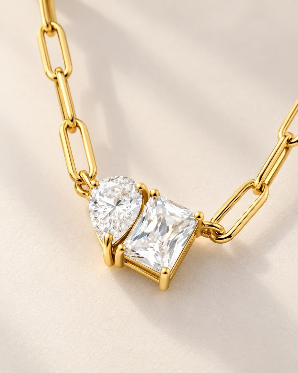 Elli Jewellery gold plated paper clip chain necklace featuring a pear and rectangle crystal pendant on a light background