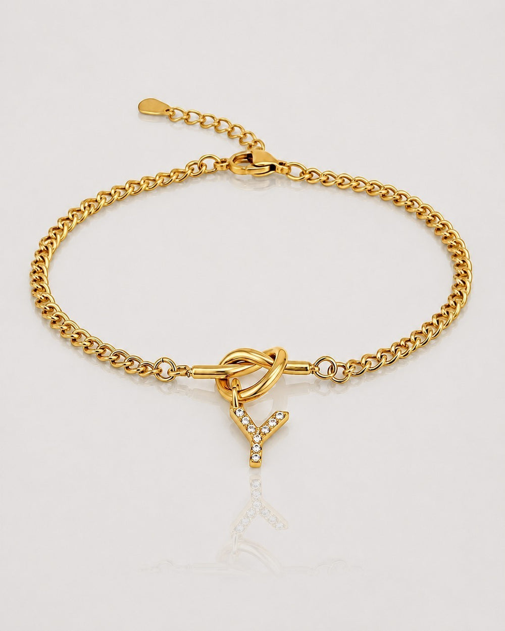 Elli Jewellery gold plated chain bracelet featuring a crystal-encrusted Y initial charm and a decorative knot detail.