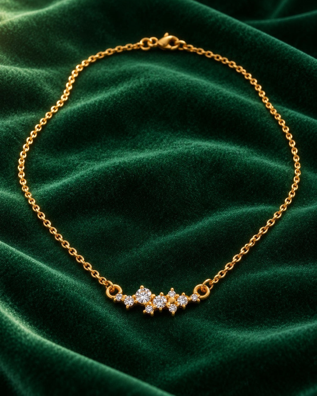 Elli Jewellery gold plated necklace featuring a delicate cubic zirconia flower pendant on a green velvet background.