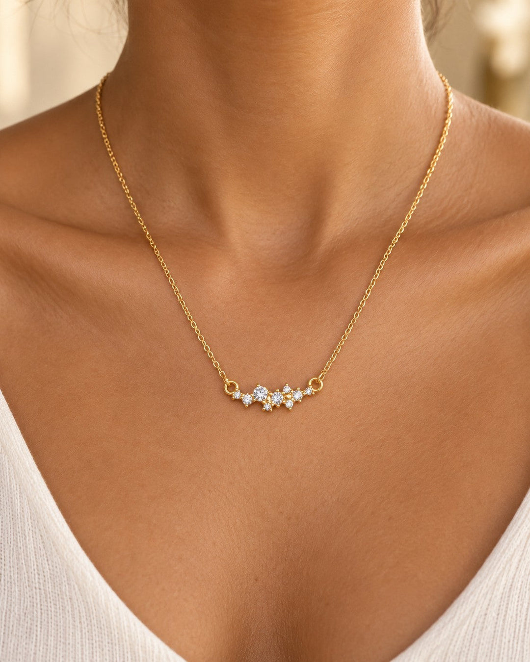 Elli Jewellery gold plated necklace with a delicate cubic zirconia flower pendant worn on a model's collarbone.