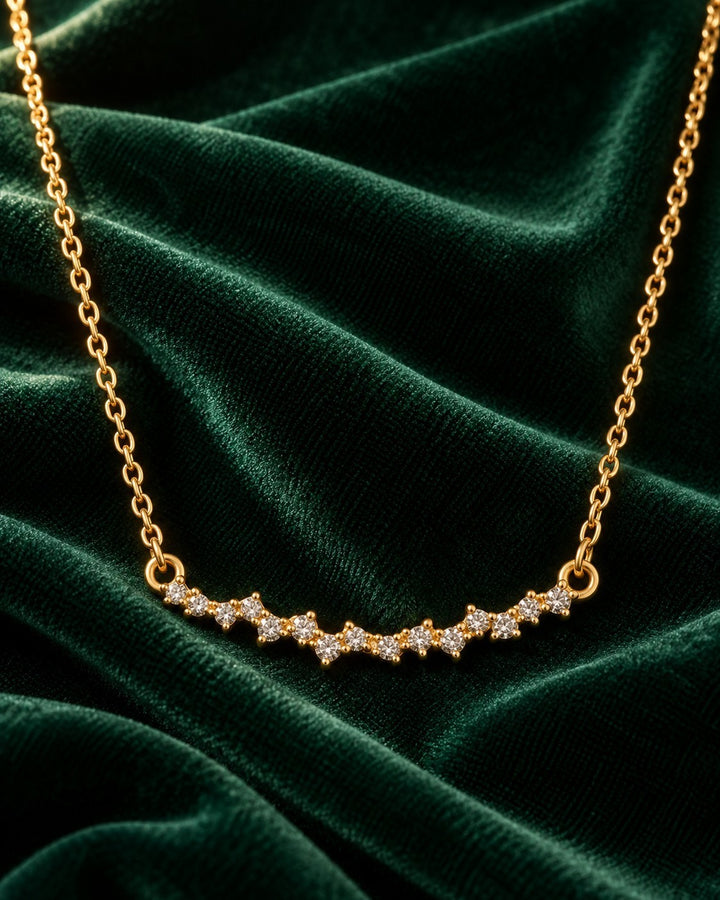 Elli Jewellery gold plated necklace featuring a delicate multi-stone cubic zirconia pendant on dark green velvet