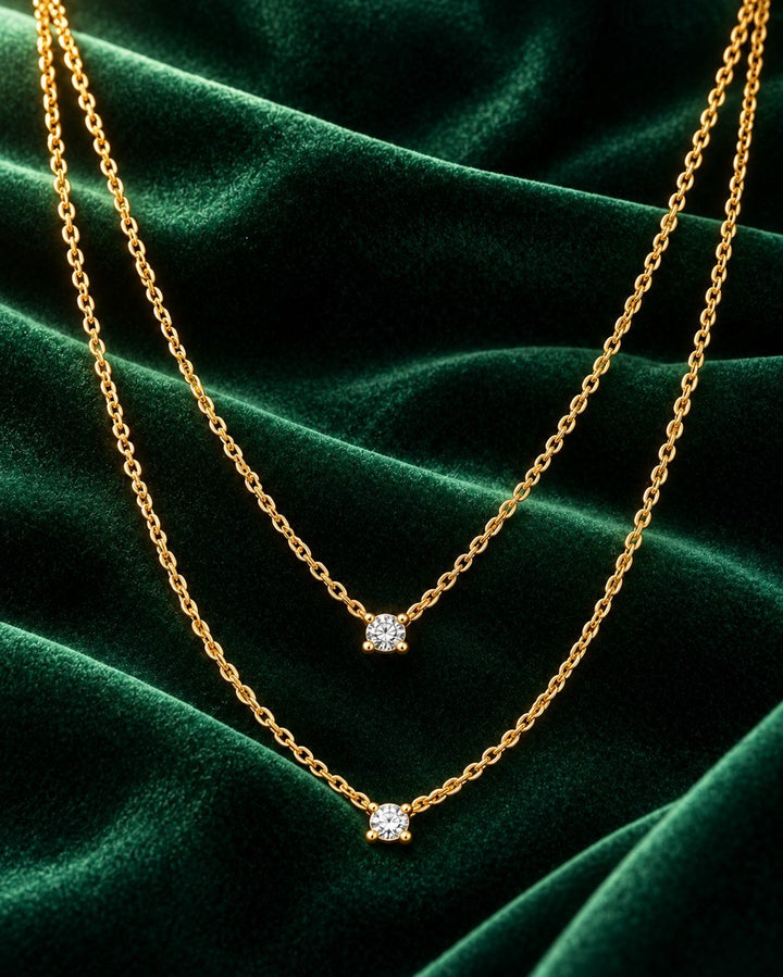 Elli Jewellery gold plated waterproof necklace with two delicate chains and sparkling CZ crystal pendants on green velvet