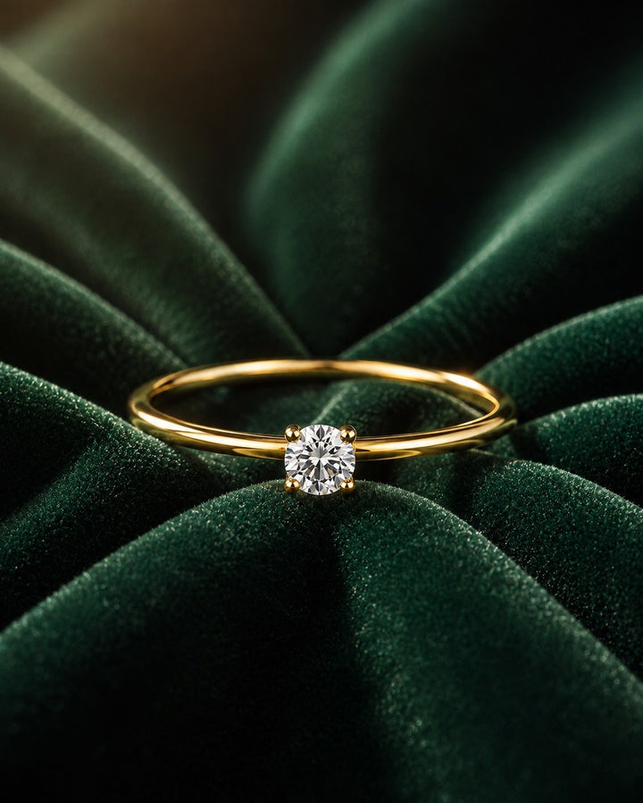 Elli Jewellery gold toned solitaire ring with a sparkling cubic zirconia stone on a dark green velvet background