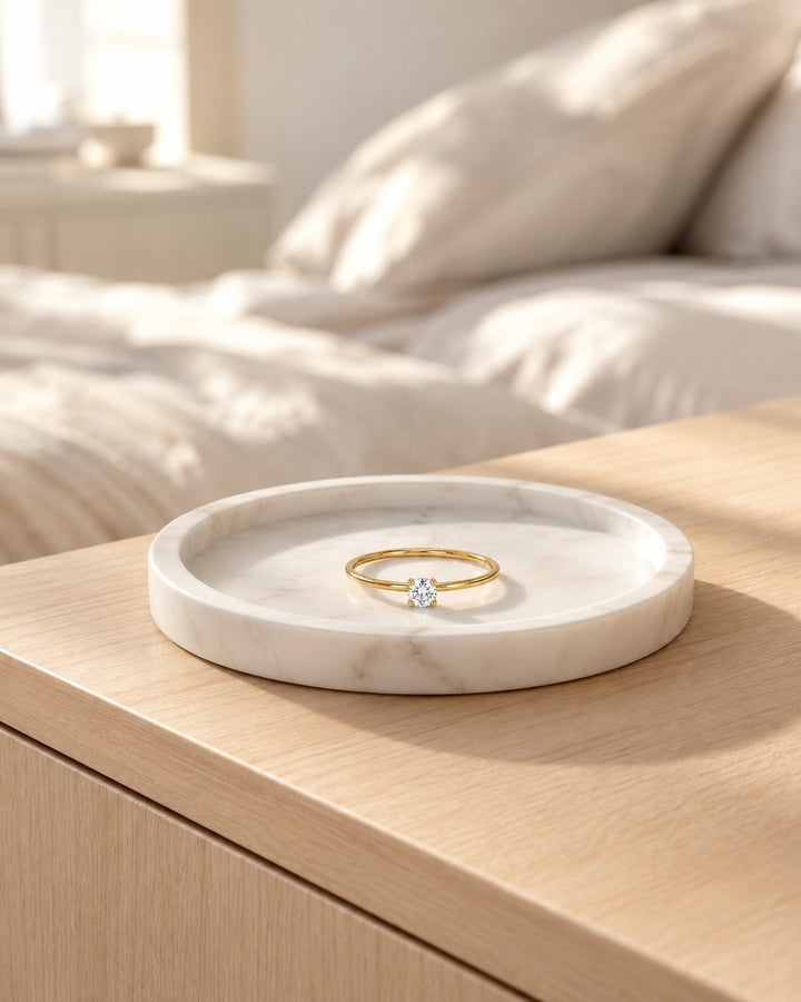Elli Jewellery gold-toned ring with a sparkling cubic zirconia stone resting on a white marble tray.