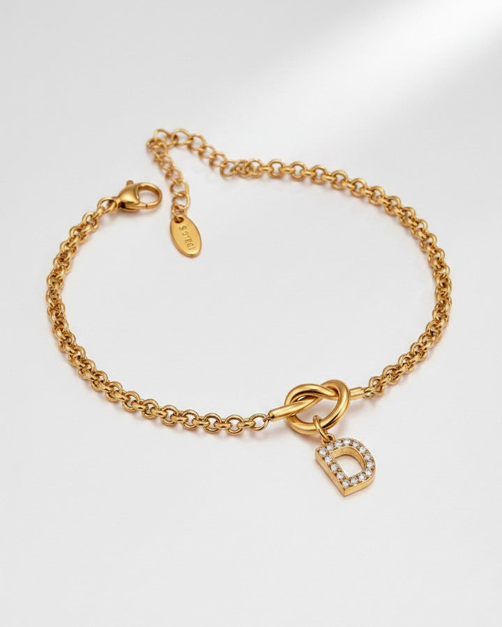 Elli Jewellery gold plated waterproof chain bracelet featuring a crystal-encrusted letter D charm on a knot detail.