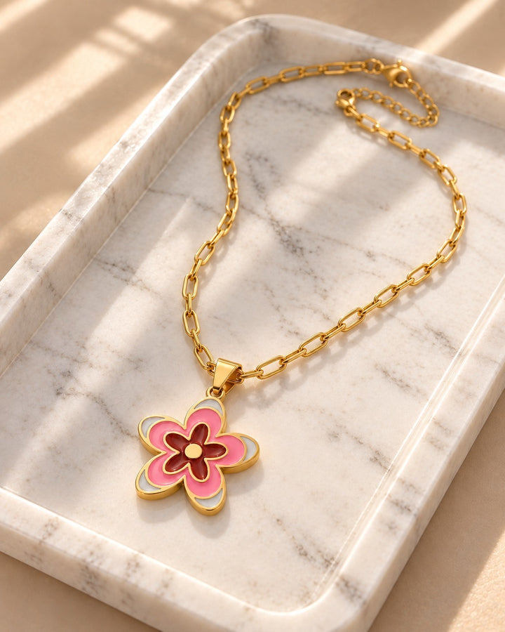 Elli Jewellery gold plated waterproof necklace featuring a pink and white enamel daisy flower pendant on a chain.