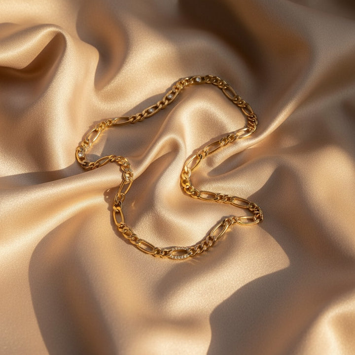 Elli Jewellery gold plated waterproof link chain necklace with diamante crystal accents on a satin background