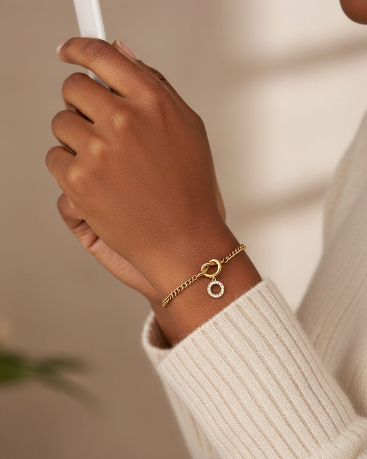 Elli Jewellery gold plated chain bracelet with a sparkling diamanté O-ring charm worn on a model's wrist.
