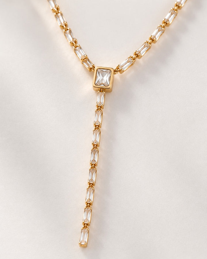 Elli Jewellery gold plated long necklace featuring baguette cut diamante crystals in a y-drop design on white silk
