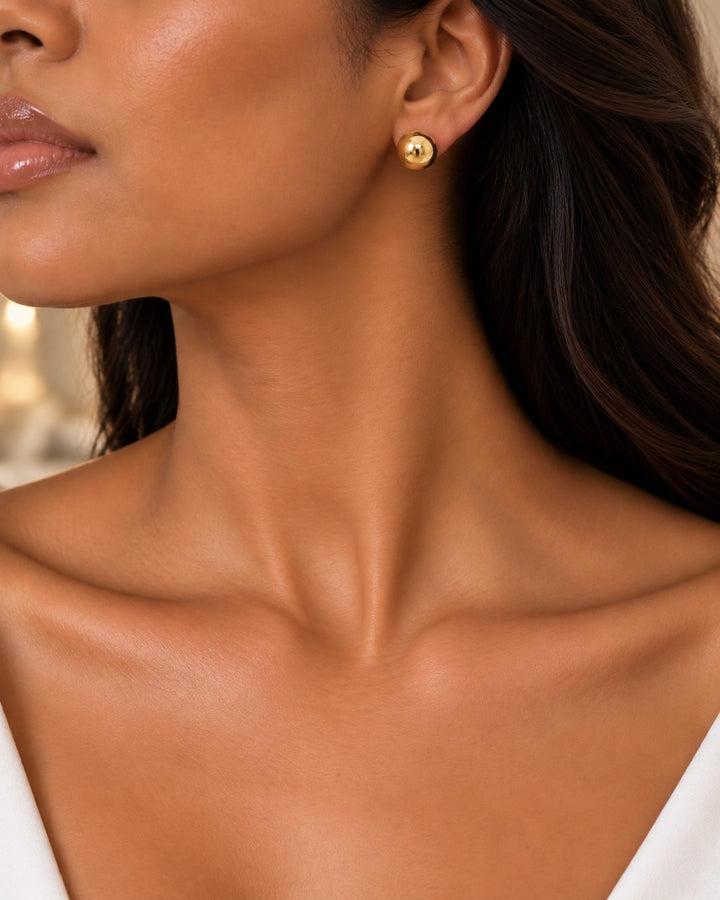 Elli Jewellery gold plated 8mm round dome stud earrings worn by a model, featuring a smooth polished finish.