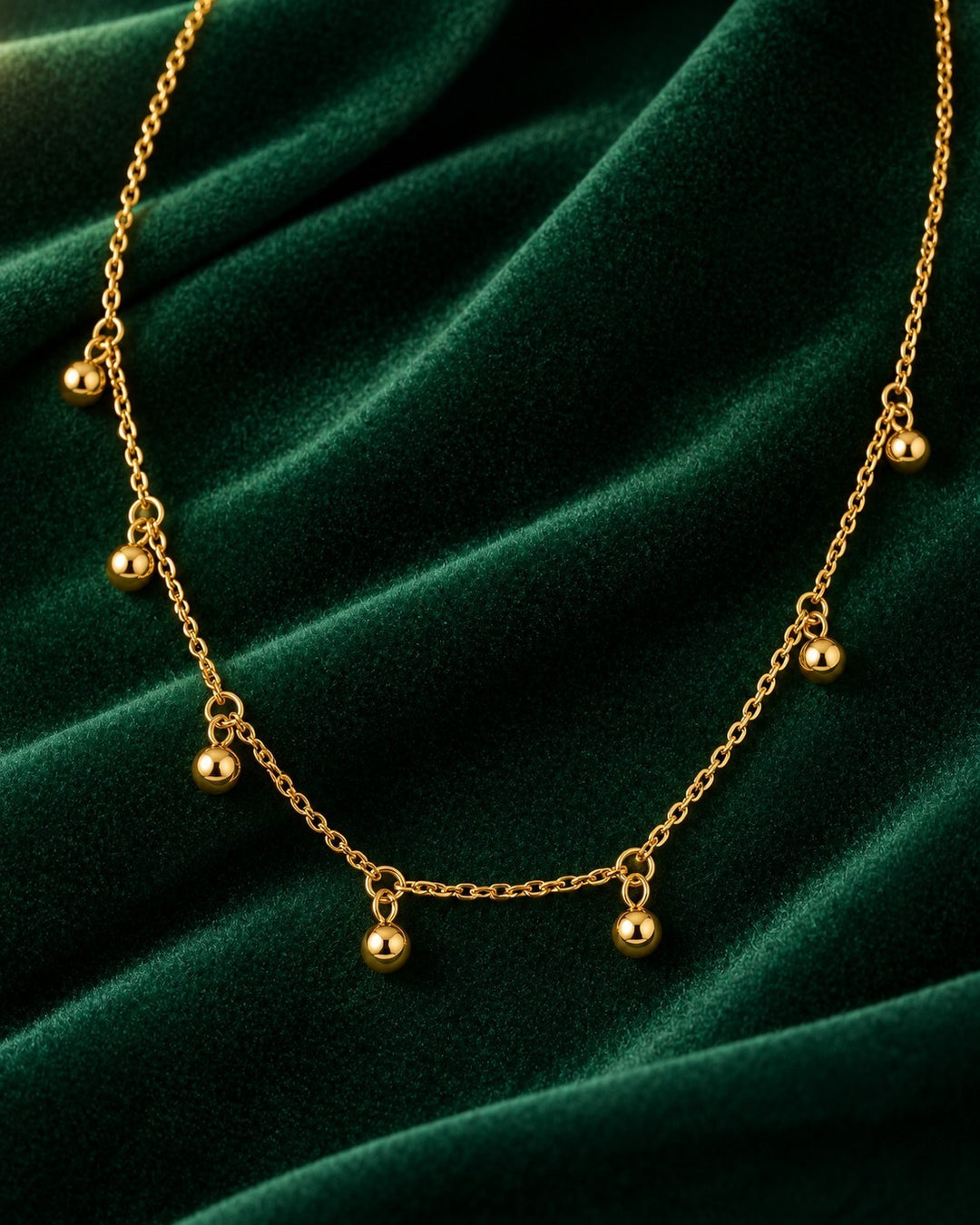Elli Jewellery gold plated choker necklace featuring delicate chain links and hanging polished dot charms on velvet