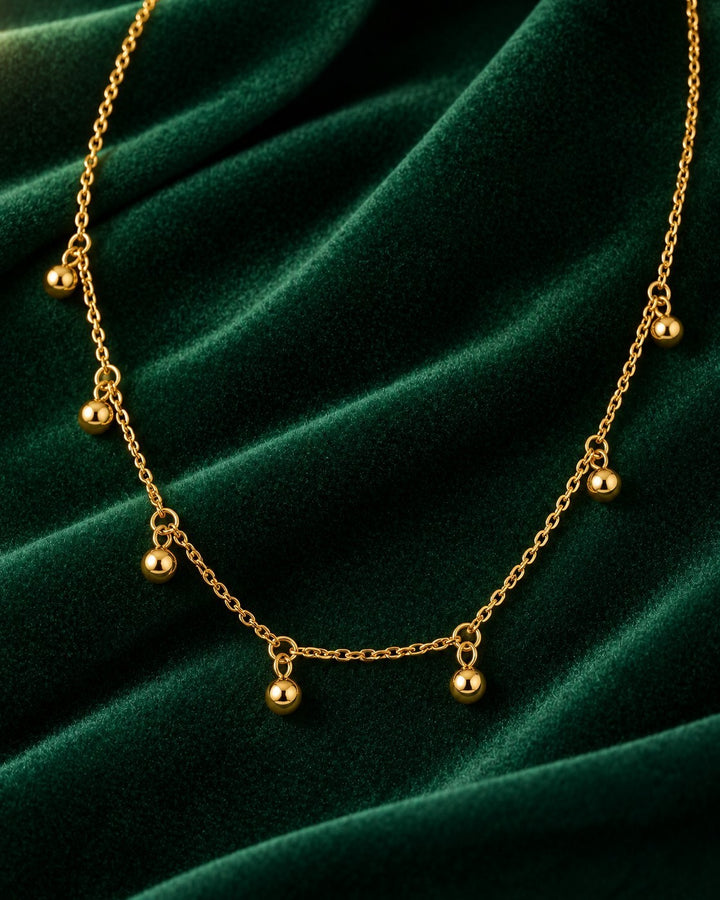 Elli Jewellery gold plated choker necklace featuring delicate chain links and hanging polished dot charms on velvet