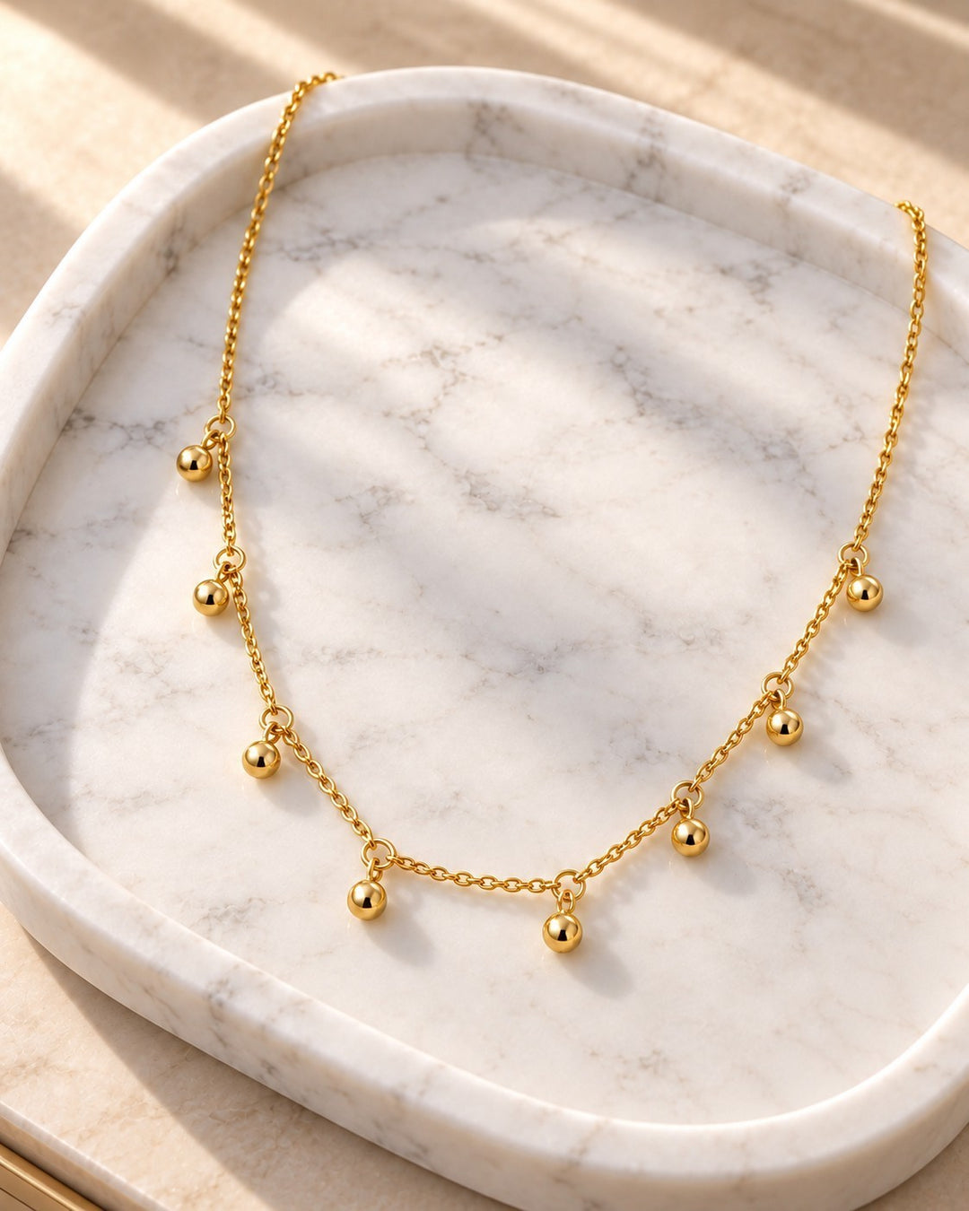 Elli Jewellery gold plated choker necklace featuring delicate dangling textured dot charms on a fine chain.