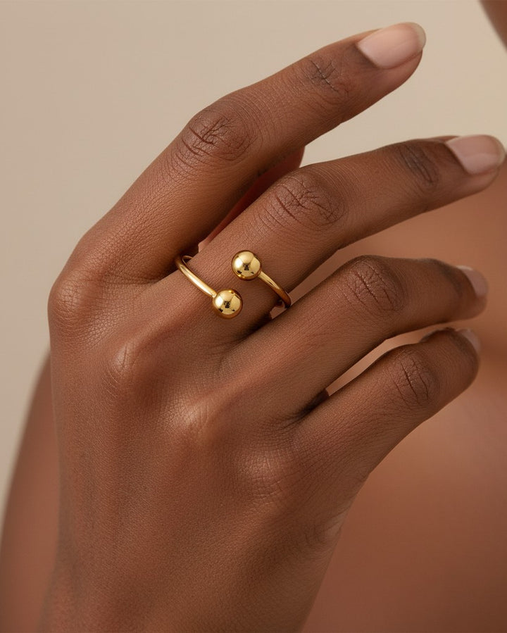 Elli Jewellery gold plated minimalist double ball ring worn on a finger, featuring a sleek, waterproof open design.
