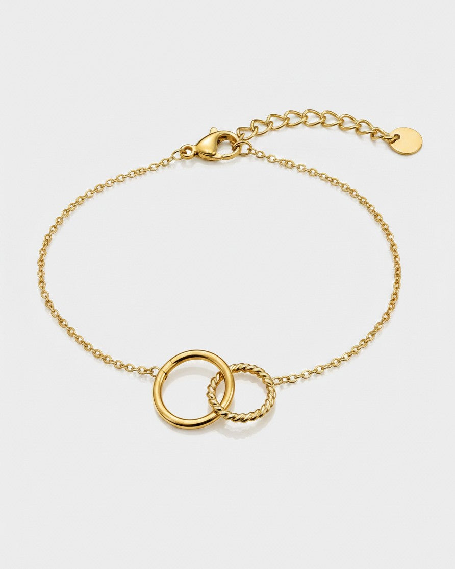 Elli Jewellery gold-toned anklet featuring two interlocking circles, one smooth and one twisted, on a delicate chain.