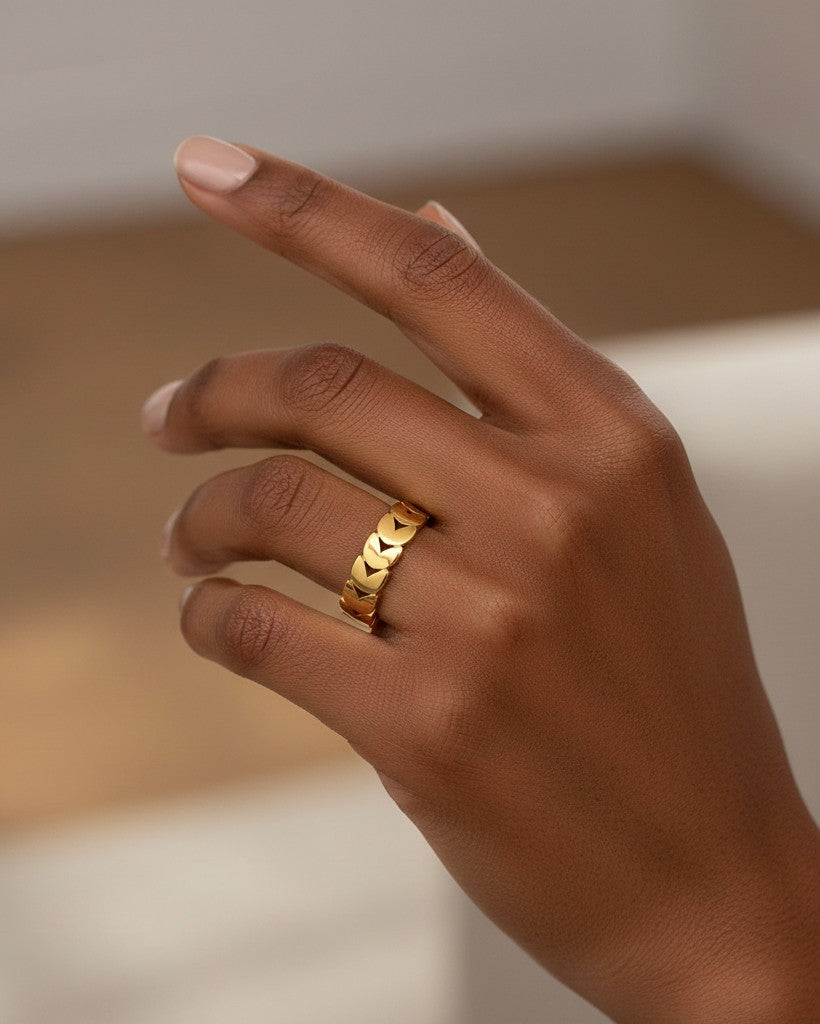 Elli Jewellery gold plated stacking ring featuring an intertwined double heart pattern worn on a woman's finger