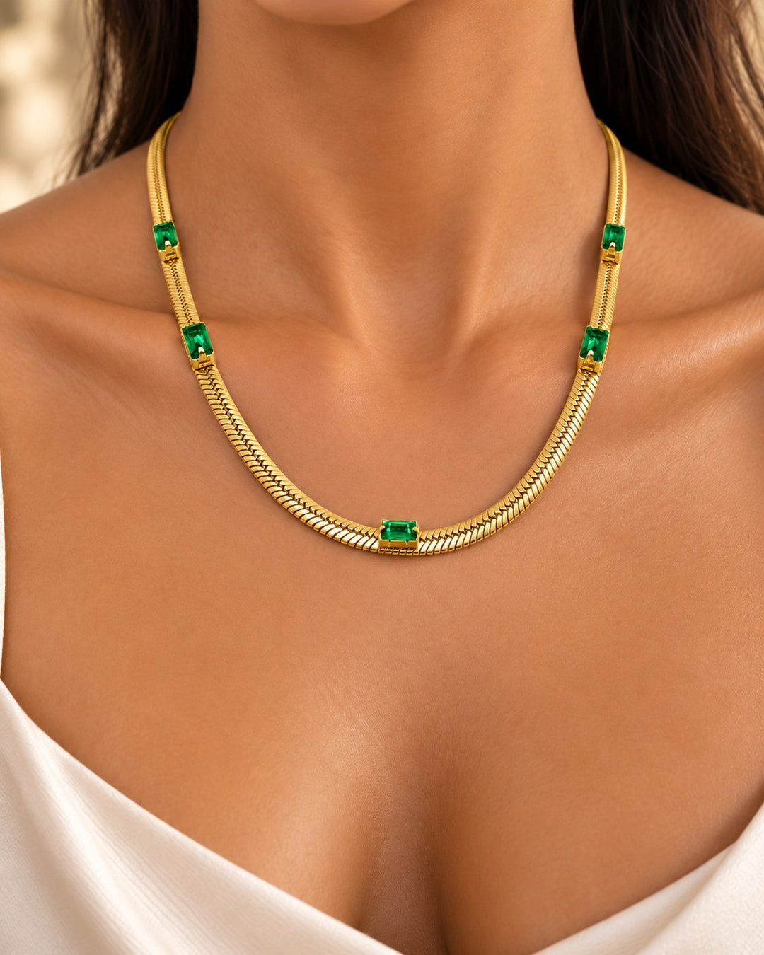 Elli Jewellery gold plated snake chain necklace featuring emerald green cubic zirconia stones worn on a model