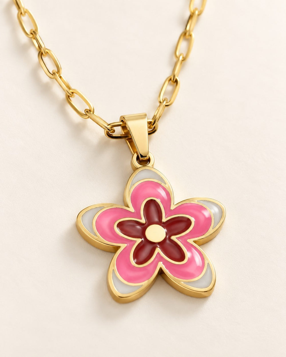 Elli Jewellery gold plated necklace featuring a pink, white, and dark red enamel daisy flower pendant on a chain.