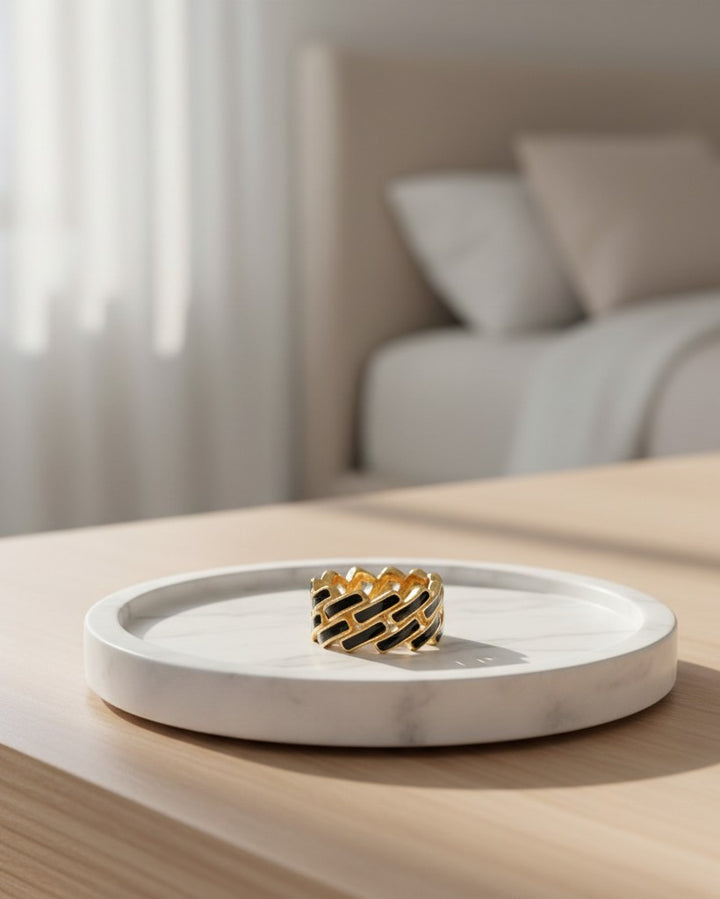 Elli Jewellery gold plated link chain ring with black and white enamel details on a marble tray.