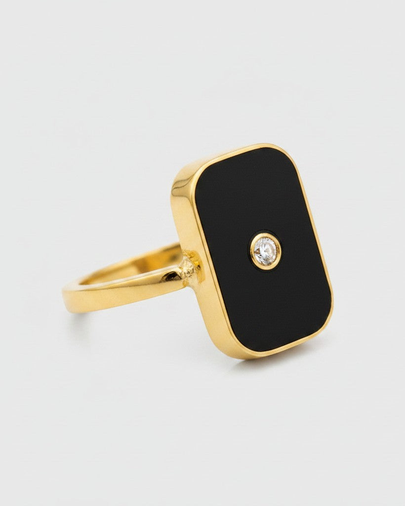 Elli Jewellery gold-plated rectangular statement ring with black enamel and a central sparkling crystal accent.