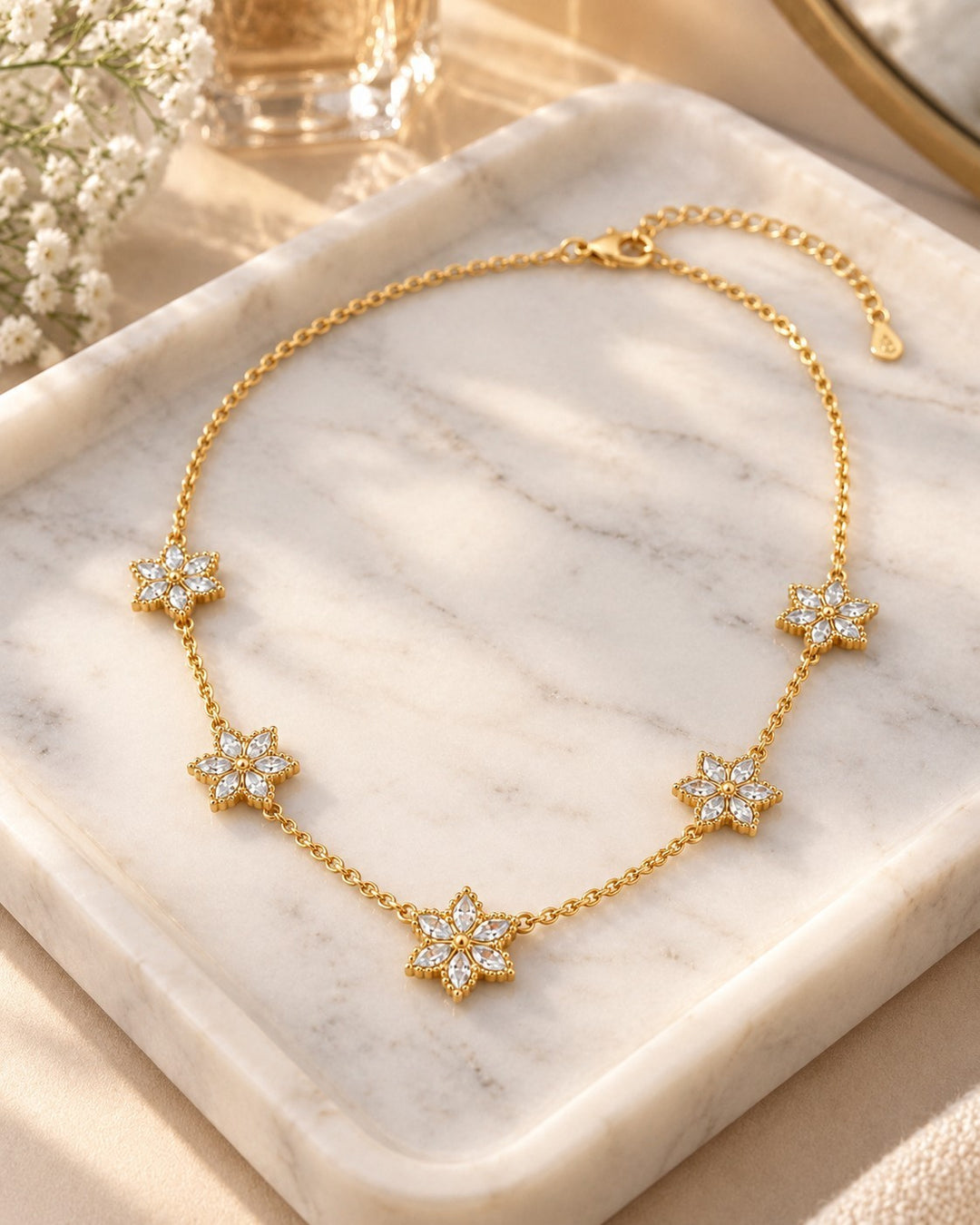 Elli Jewellery gold plated necklace featuring five delicate floral bloom pendants with sparkling white crystals.