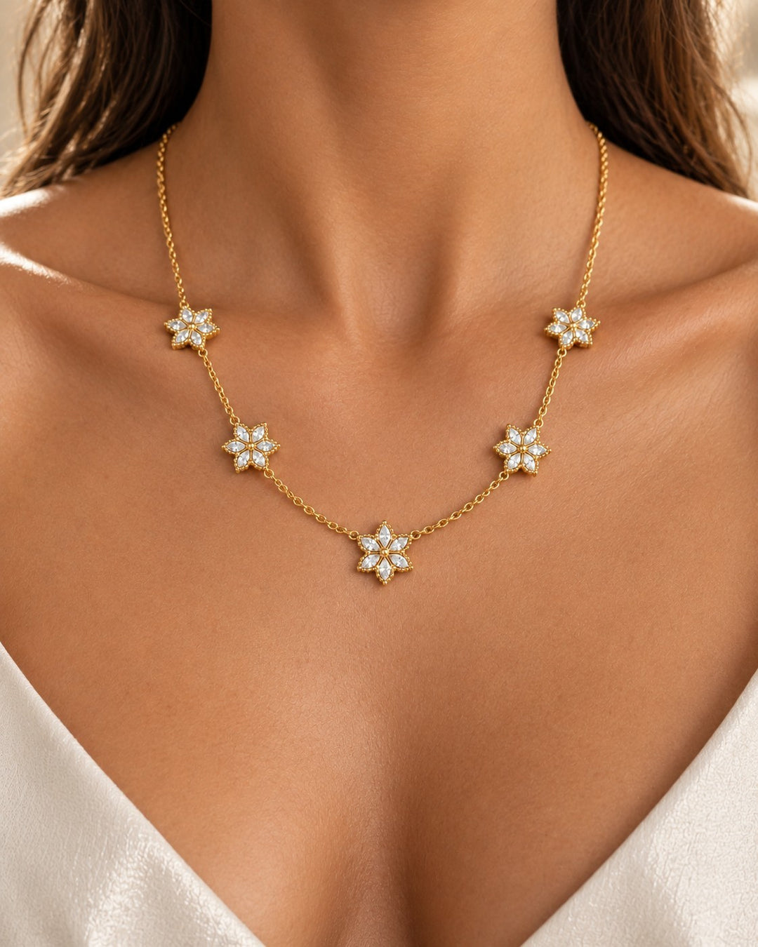 Elli Jewellery gold plated necklace featuring delicate floral bloom pendants with sparkling white stones on a chain.