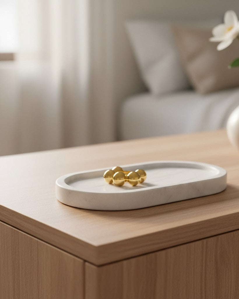 Elli Jewellery gold plated statement ring with a graduated sphere design resting on a white marble tray.