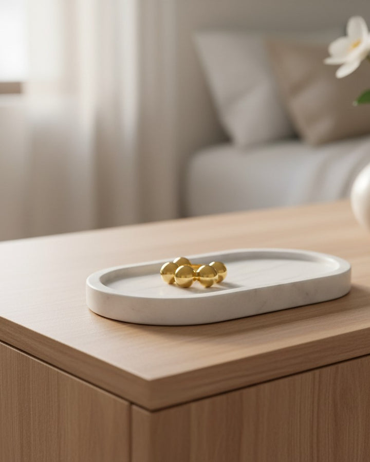 Elli Jewellery gold plated statement ring with a graduated sphere design resting on a white marble tray.