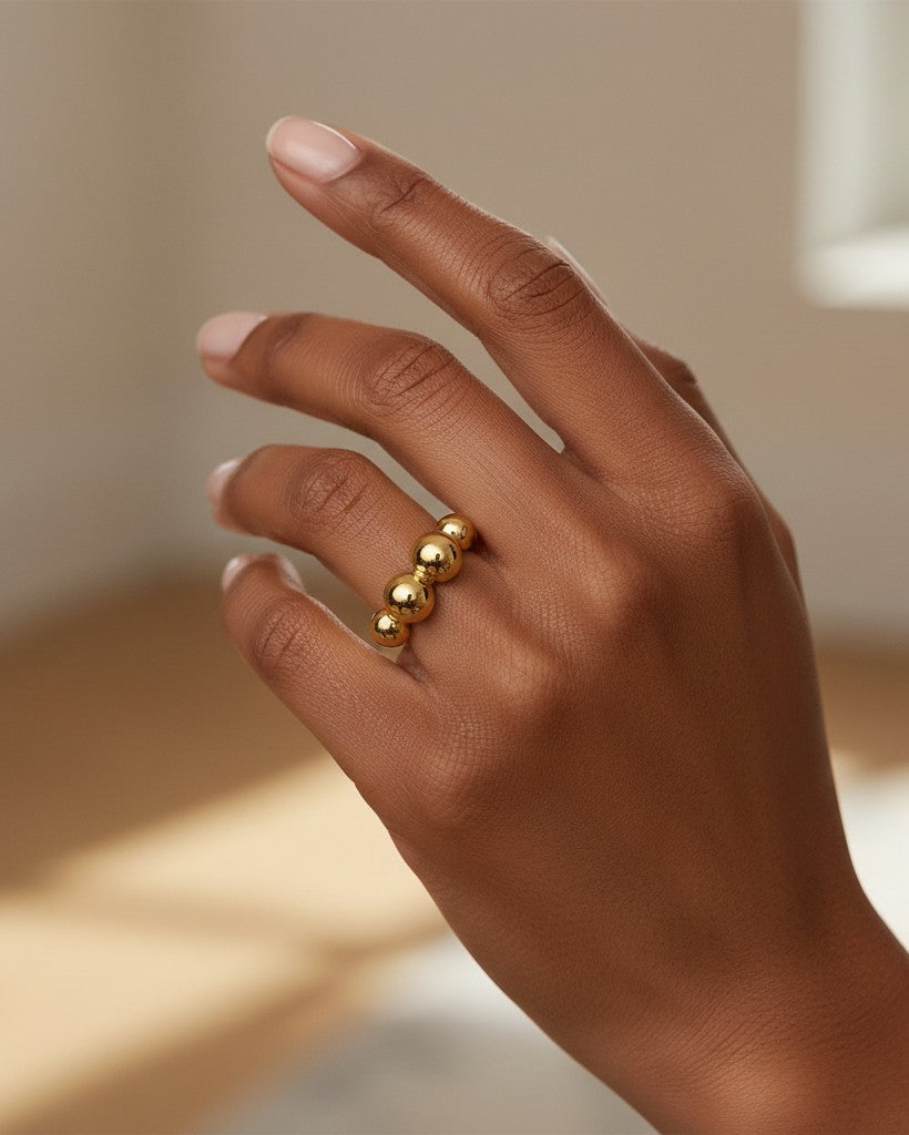 Elli Jewellery gold plated statement ring featuring a row of graduated spheres worn on a model's finger
