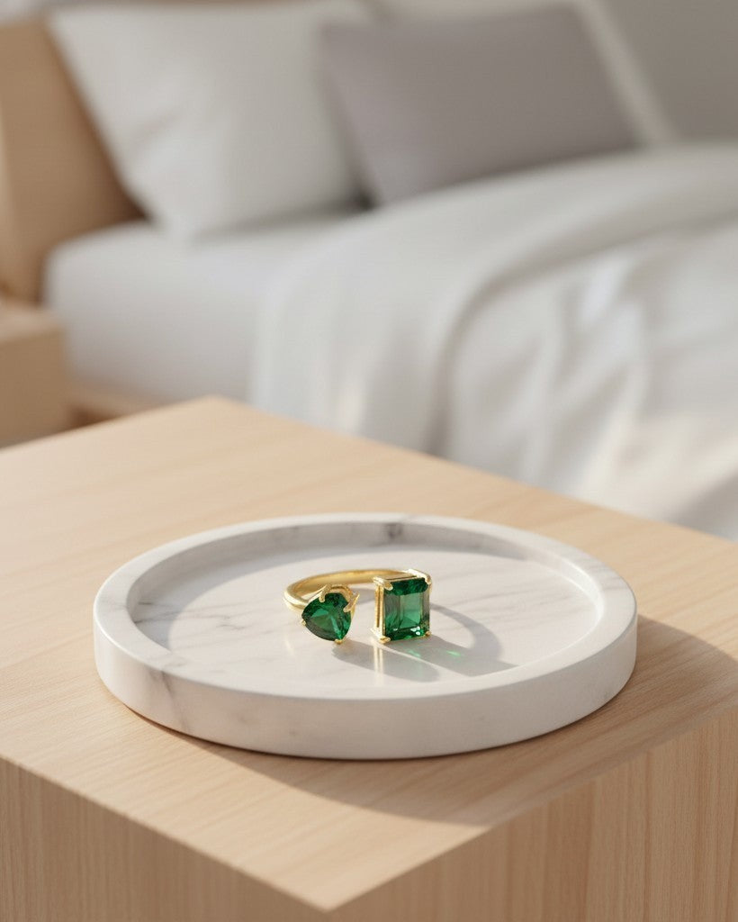Elli Jewellery gold plated adjustable ring with green cubic zirconia crystals on a marble tray.