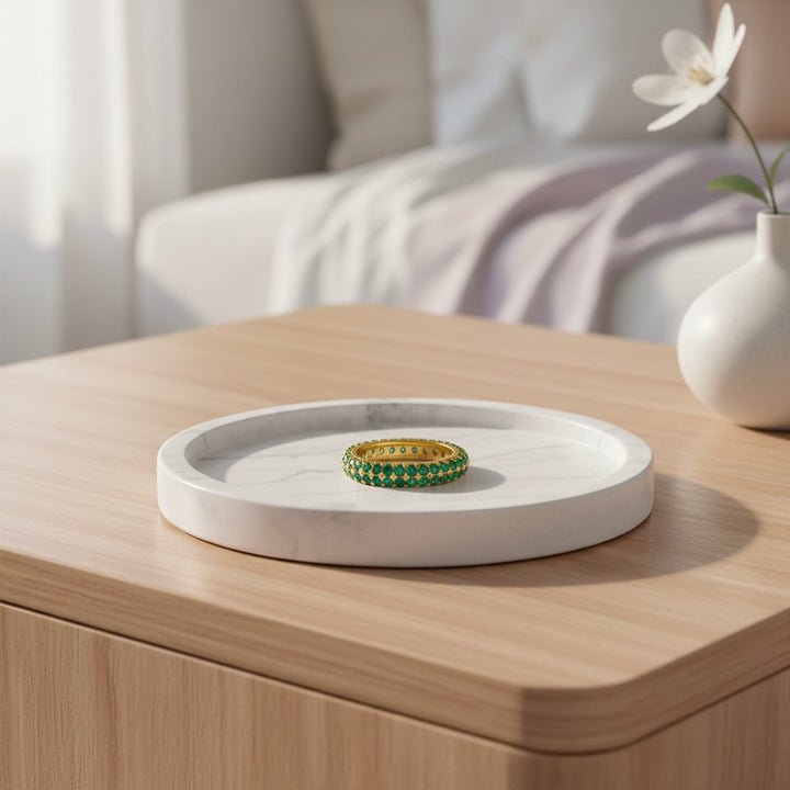 Elli Jewellery gold plated pavé ring with green crystals resting on a white marble tray on a wooden table