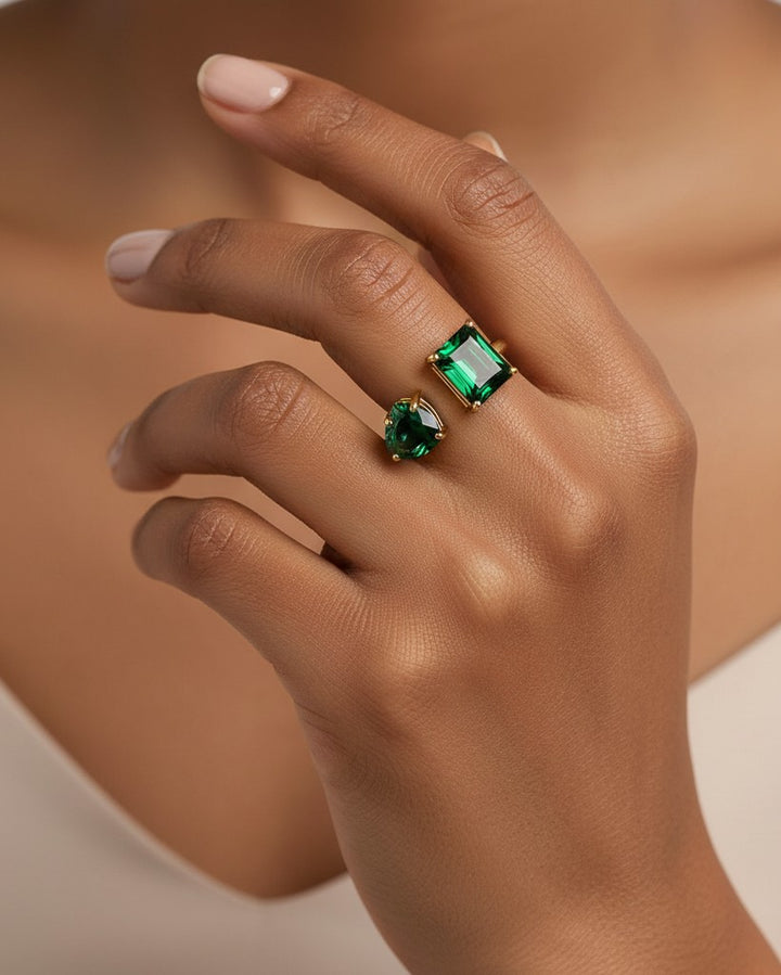 Elli Jewellery gold plated adjustable ring with emerald-cut and pear-cut green cubic zirconia stones on a hand.