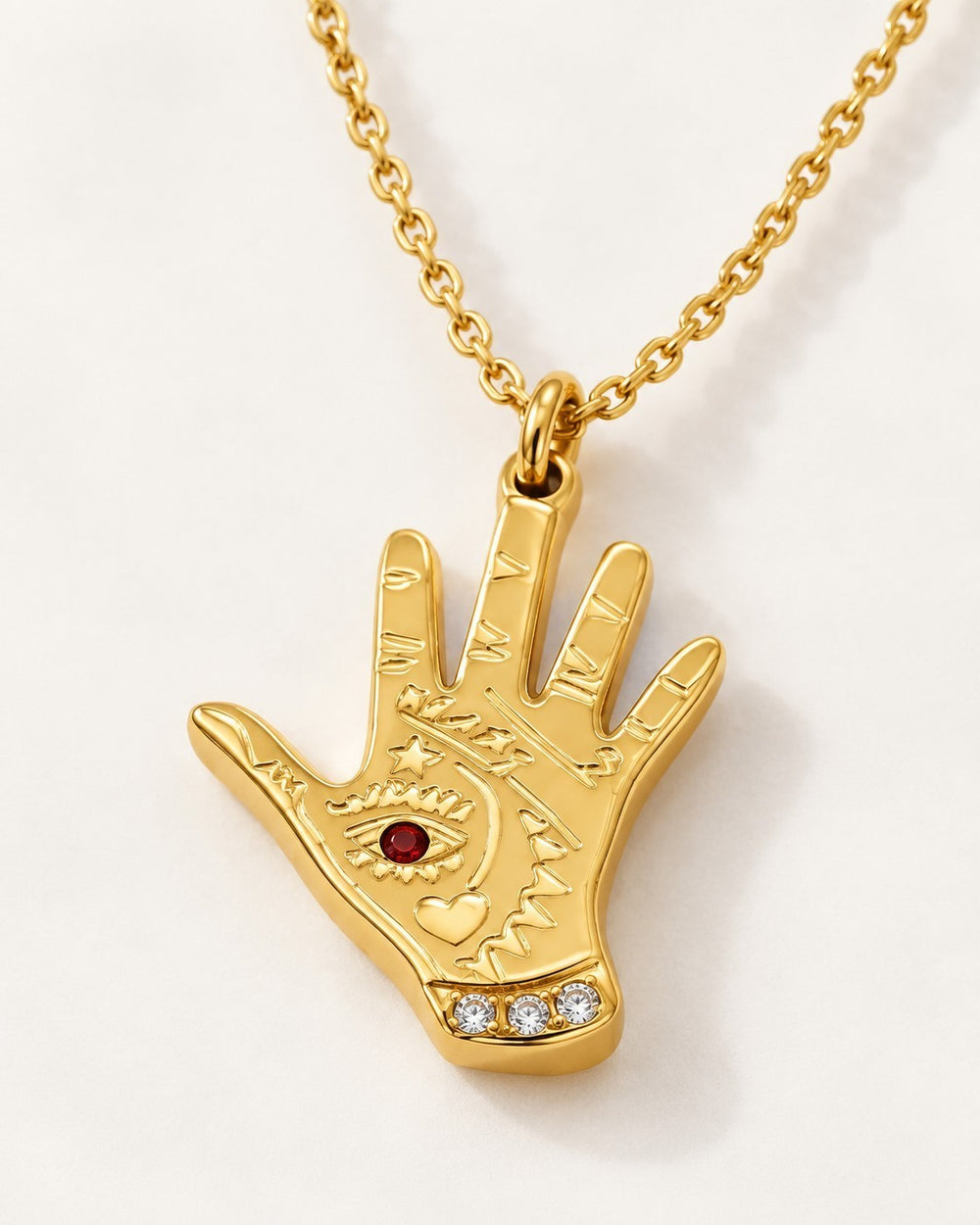 Elli Jewellery gold plated hamsa hand pendant necklace featuring an evil eye with a red stone and crystal accents.