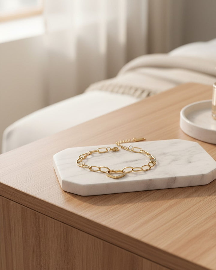 Elli Jewellery gold plated hollow heart bracelet with diamanté accents on a marble display tray