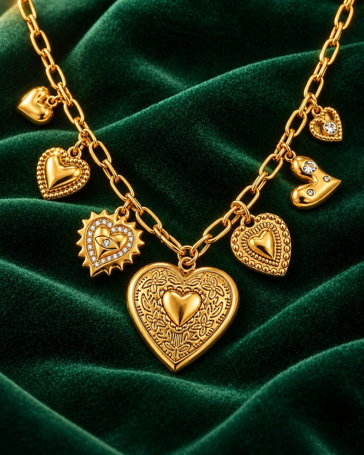 Elli Jewellery gold plated charm necklace featuring a large heart locket and smaller heart charms on a velvet background