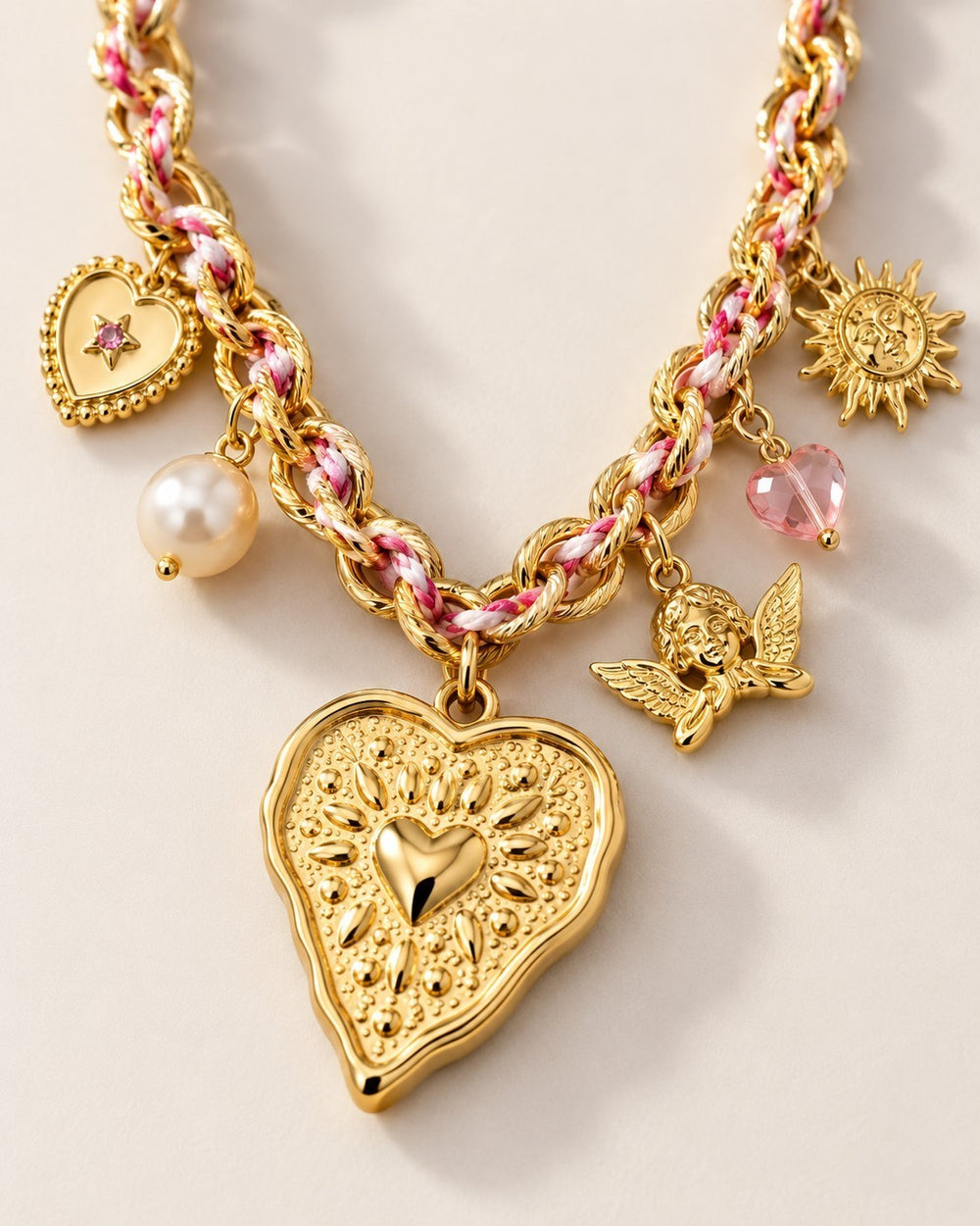 Elli Jewellery gold plated charm necklace featuring a large heart beam pendant, angel, sun, and pearl charms.