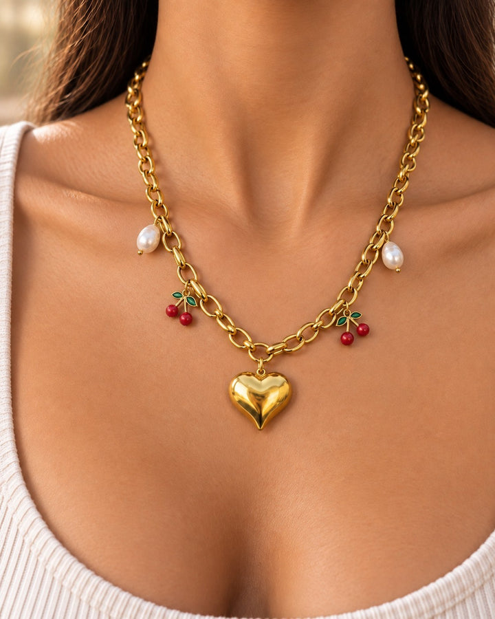 Elli Jewellery gold plated chain necklace with heart, cherry, and pearl charms worn on a model