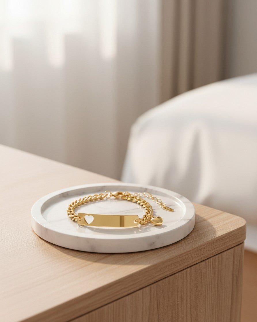 Elli Jewellery gold plated waterproof ID bracelet with a heart cutout on a marble tray