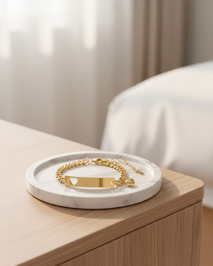Elli Jewellery gold plated waterproof ID bracelet with a heart cutout on a marble tray