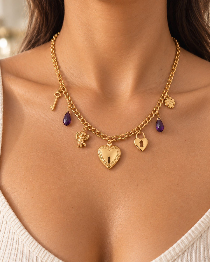 Elli Jewellery gold plated charm necklace featuring a heart locket, purple crystals, and delicate key charms.