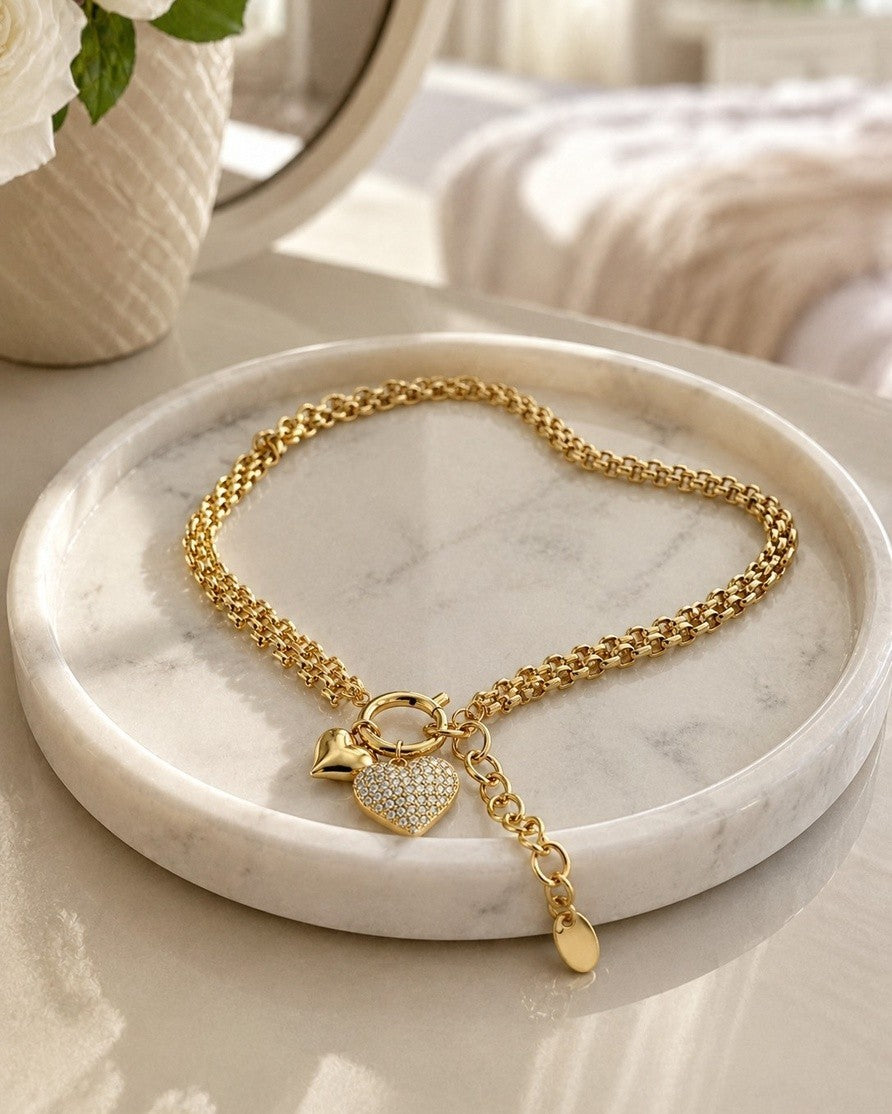 Elli Jewellery gold plated waterproof heart charm necklace with crystal accents on a marble tray