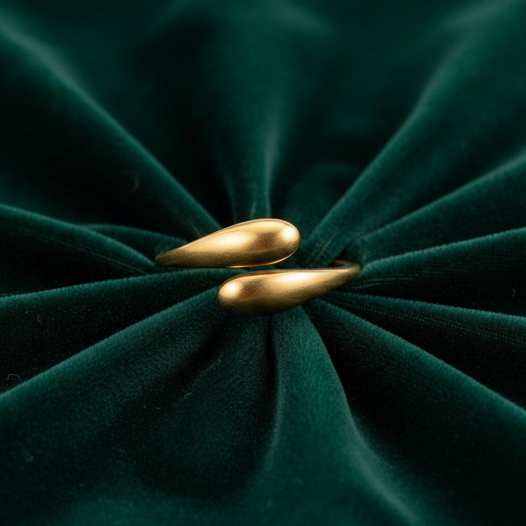 Elli Jewellery gold plated minimalist hug wrap ring with a sleek sculptural design on a dark green velvet background