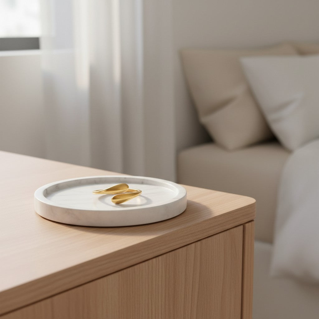 Elli Jewellery gold plated minimalist hug wrap ring resting on a white marble tray on a wooden bedside table.