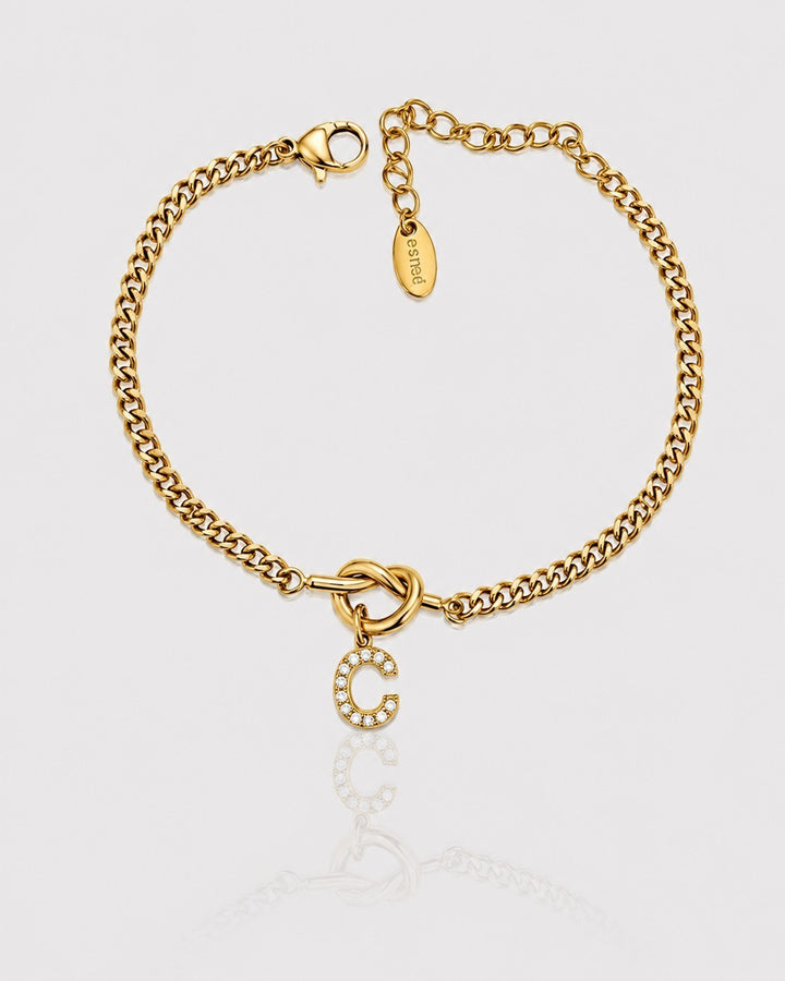 Elli Jewellery gold plated curb chain bracelet featuring a sparkling diamanté C initial charm on a knot detail.