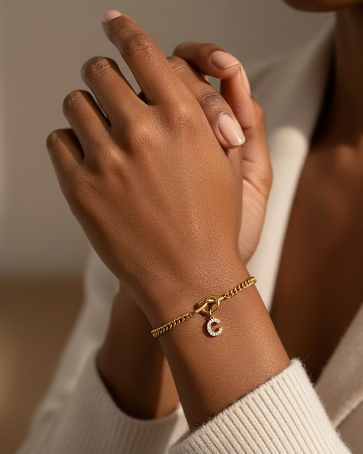 Elli Jewellery gold plated chain bracelet featuring a sparkling diamanté C initial charm worn on a wrist.