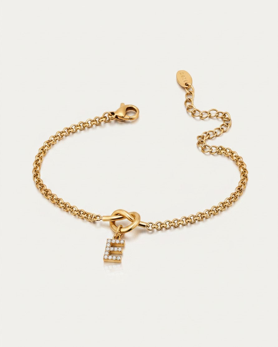 Elli Jewellery gold plated waterproof chain bracelet featuring a sparkling diamanté letter E charm on a knot detail.