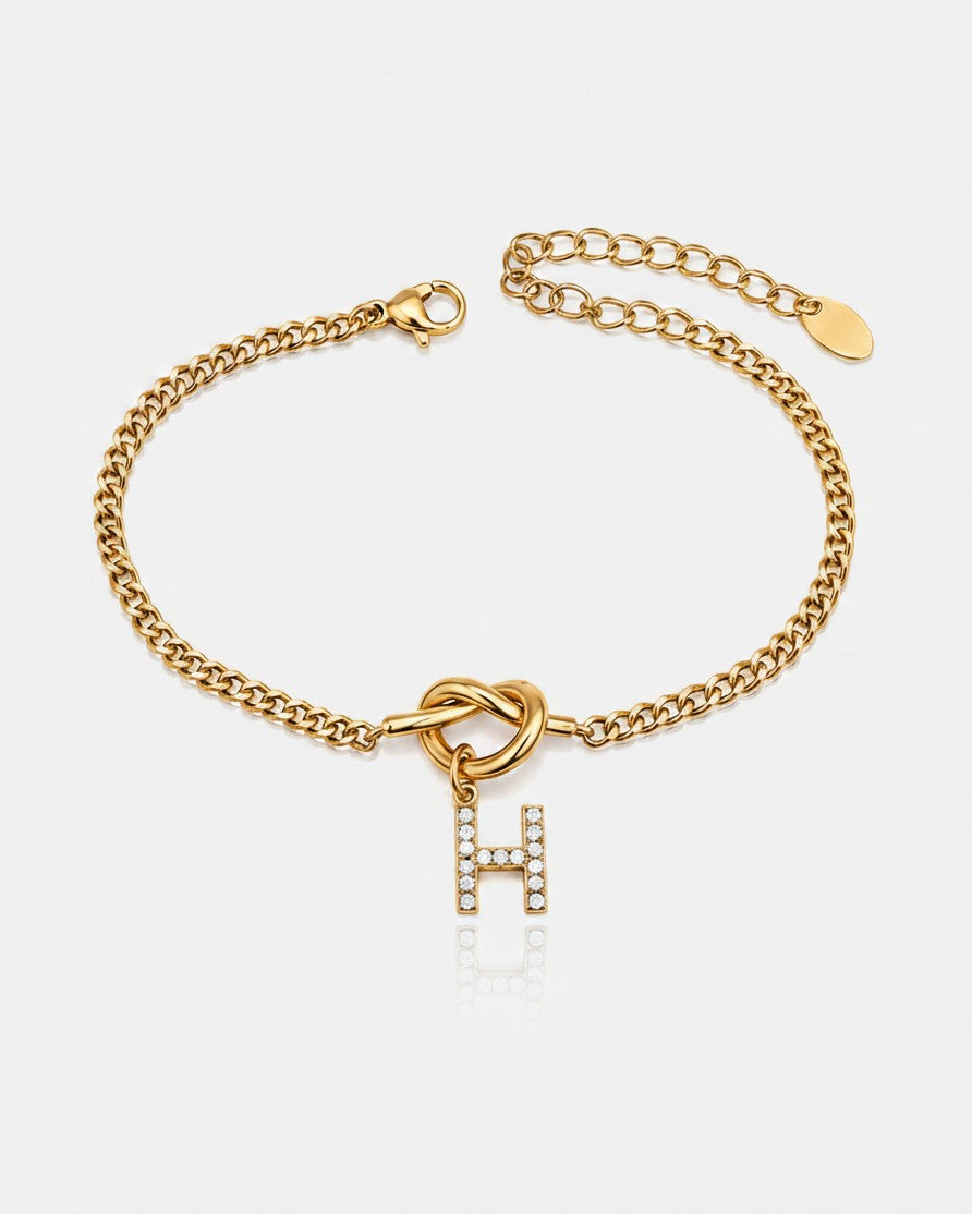 Elli Jewellery gold plated chain bracelet featuring a sparkling diamante-encrusted letter H charm with a knot detail.