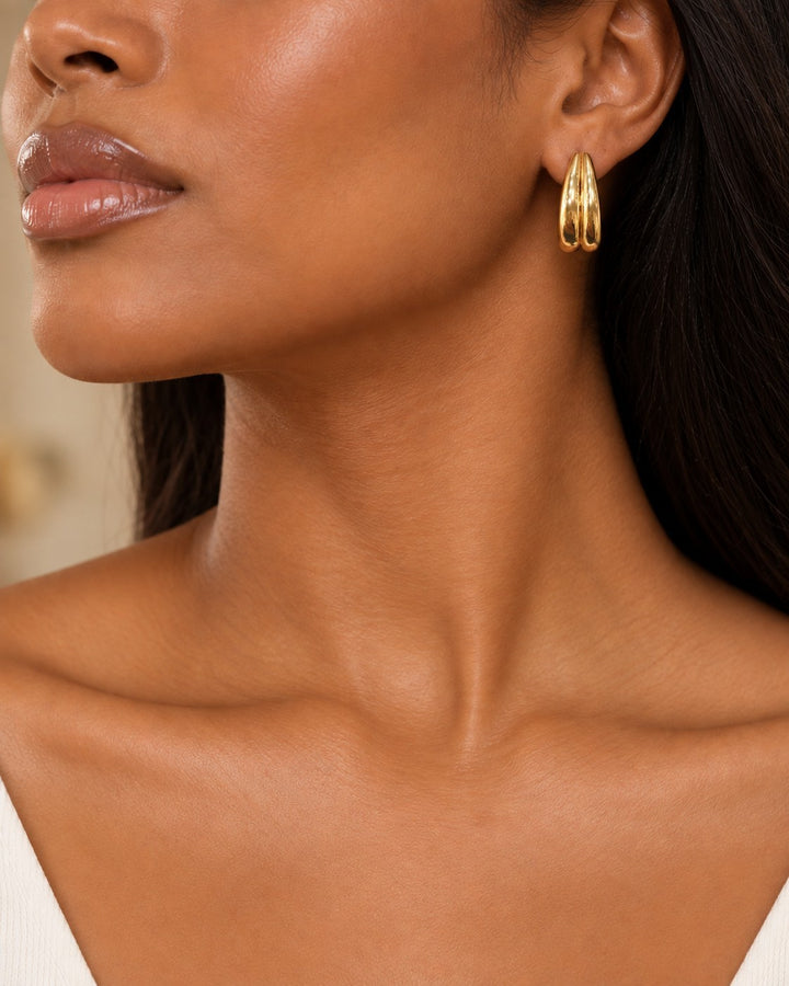 Elli Jewellery gold plated waterproof interlocking double C hoop earrings worn by a model